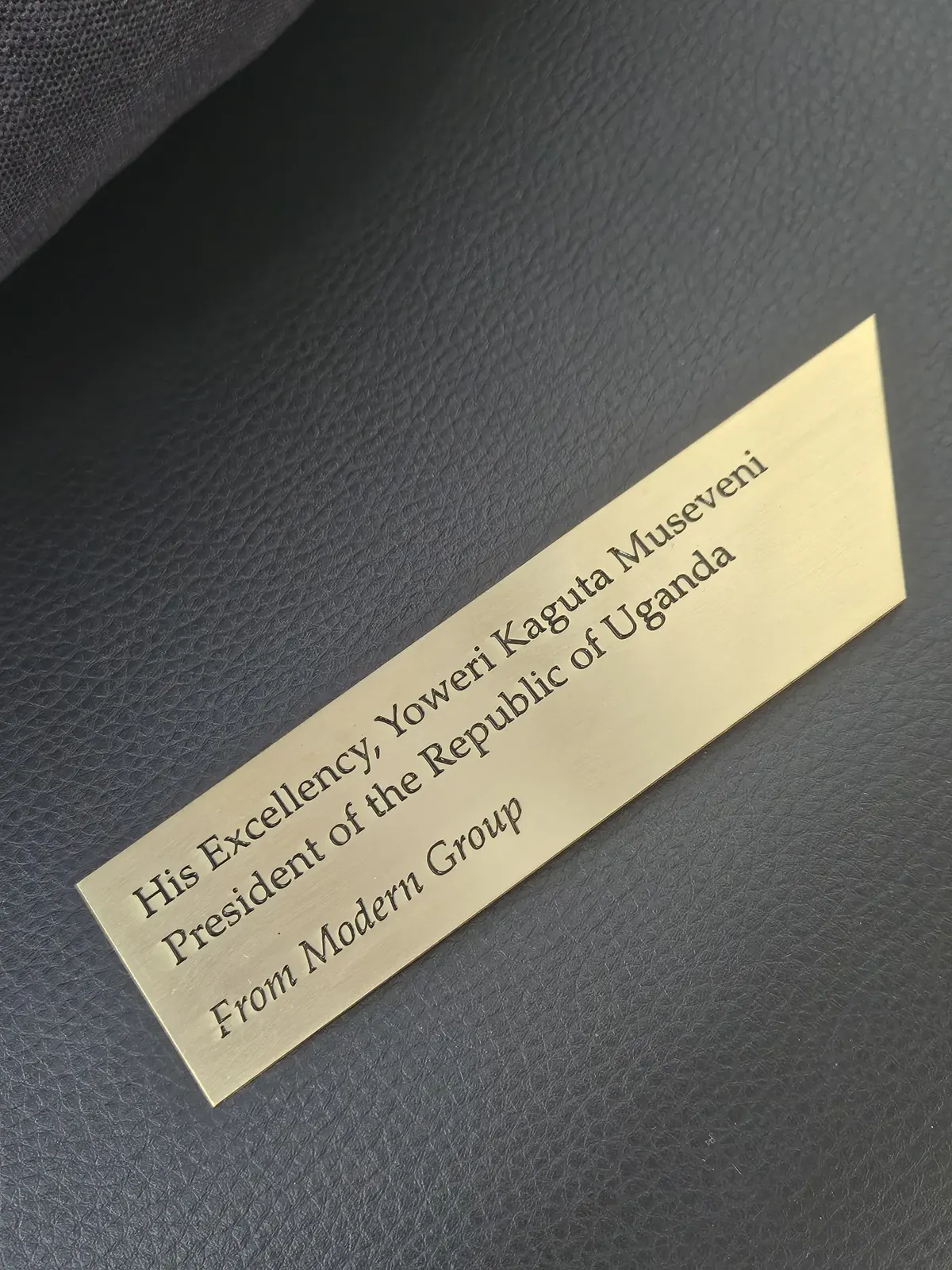 Engraved brass plaque on black leather