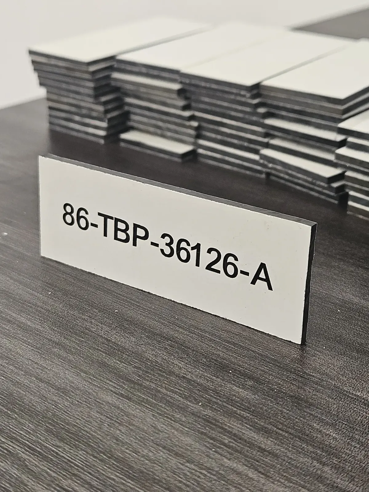 Engraved traffolyte tag reading 86-TBP-36126-A